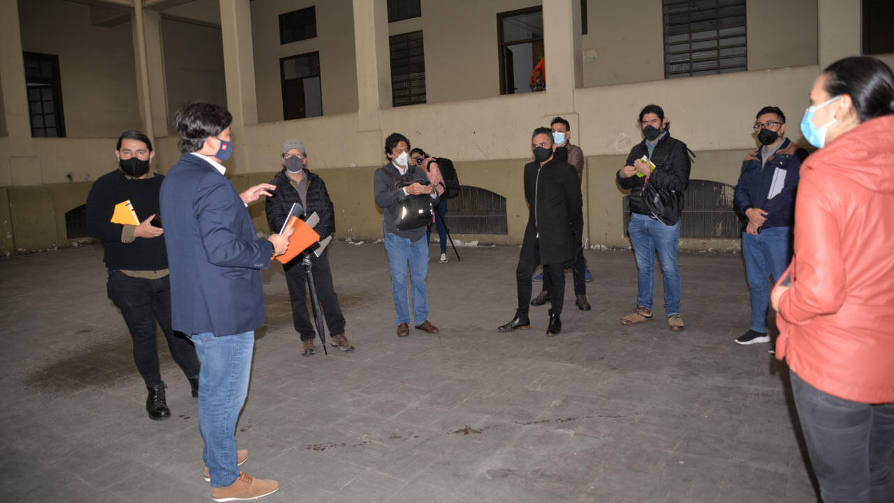 Varias personas reunidas en circulo en edificio cerrado